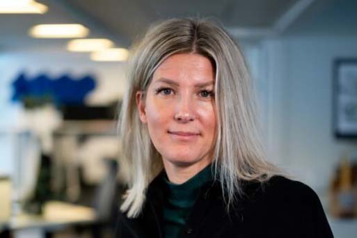 Blond kvinna som ler mot kameran